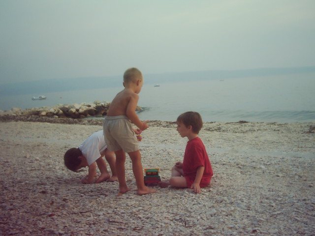 Drei Kinder spielen am Meer